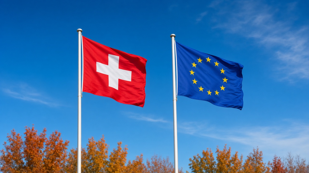 A Swiss flag and a European Union flag flying side by side on tall flagpoles against a bright sky